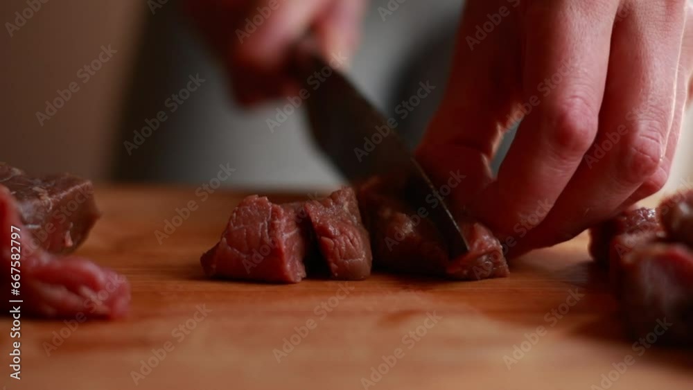 woman hands close up cutting raw beef in small pieces for a stew. Cooking at home woman hands close up cutting raw beef in small pieces for a stew. Cooking at home