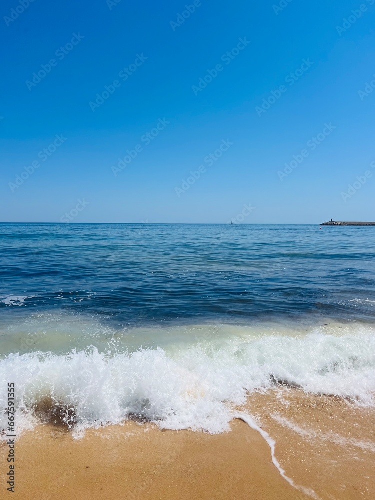Blue sea horizon, waves seascape, blue clear sky, sandy coast Blue sea horizon, waves seascape, blue clear sky, sandy coast