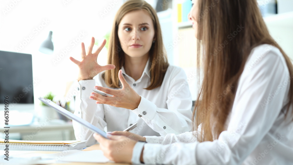 Portrait of concerned businesswoman sitting in modern workplace and discussing important topic. Pretty business lady working on project. Accounting office concept Portrait of concerned businesswoman sitting in modern workplace and discussing important topic. Pretty business lady working on project. Accounting office concept