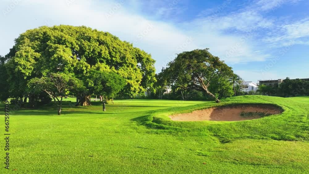 Green field, trees, blue sky and sand bunkers on a beautiful golf course. Tropical landscape. Golf holidays in the Dominican Republic. Golf course with fairway. Green field, trees, blue sky and sand bunkers on a beautiful golf course. Tropical landscape. Golf holidays in the Dominican Republic. Golf course with fairway.