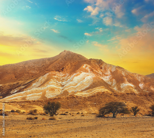 Mountainous desert with colorful cloudy sky. Judean desert in Israel at sunset