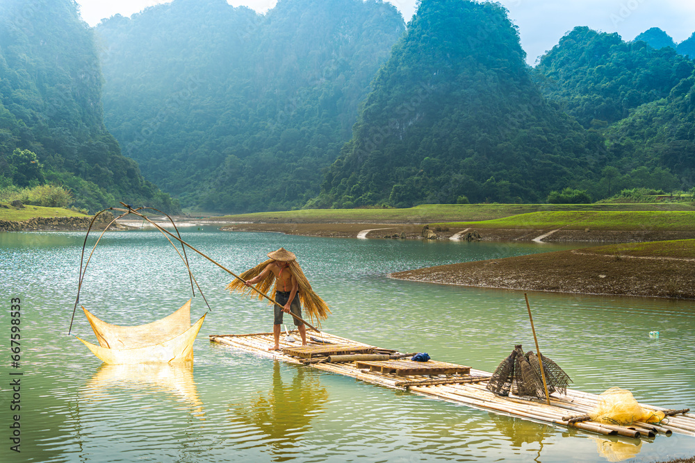Fototapeta premium view of fishermen fishing on river in Thung mountain in Tra Linh, Cao Bang province, Vietnam with lake, cloudy, nature