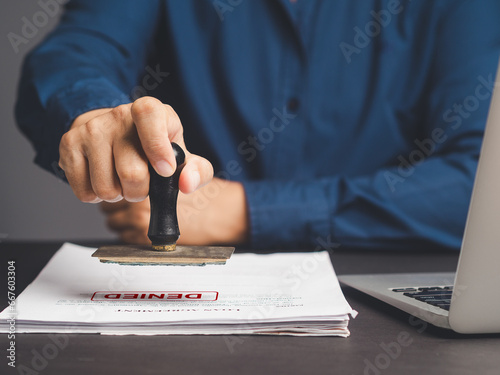 Businessman stamped for denied documents while sitting at the table.