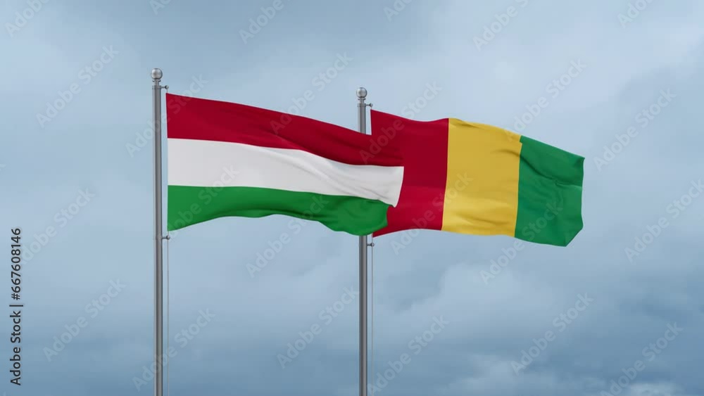 Republic of Guinea flag and Hungary flag waving together on cloudy sky, endless seamless loop, two country relations concept Republic of Guinea flag and Hungary flag waving together on cloudy sky, endless seamless loop, two country relations concept