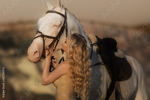 Cheerful bright girl leans on the horse, eyes closed, hand on the hair. Fashion blonde in the red dress. photo