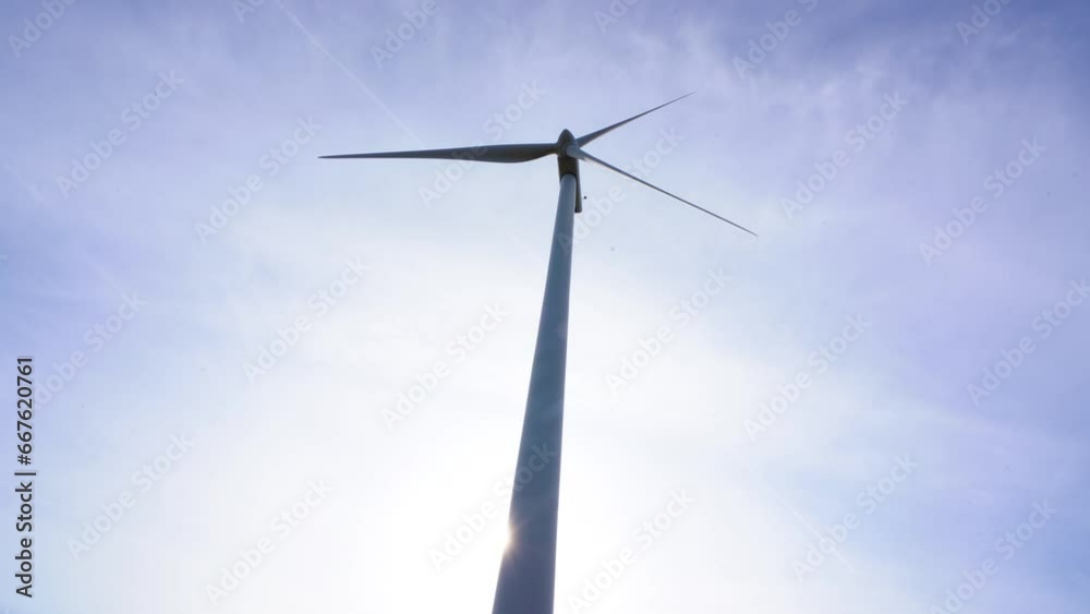 Large wind turbine with blades and blue skies behind view from the floor looking up in Italy Large wind turbine with blades and blue skies behind view from the floor looking up in Italy