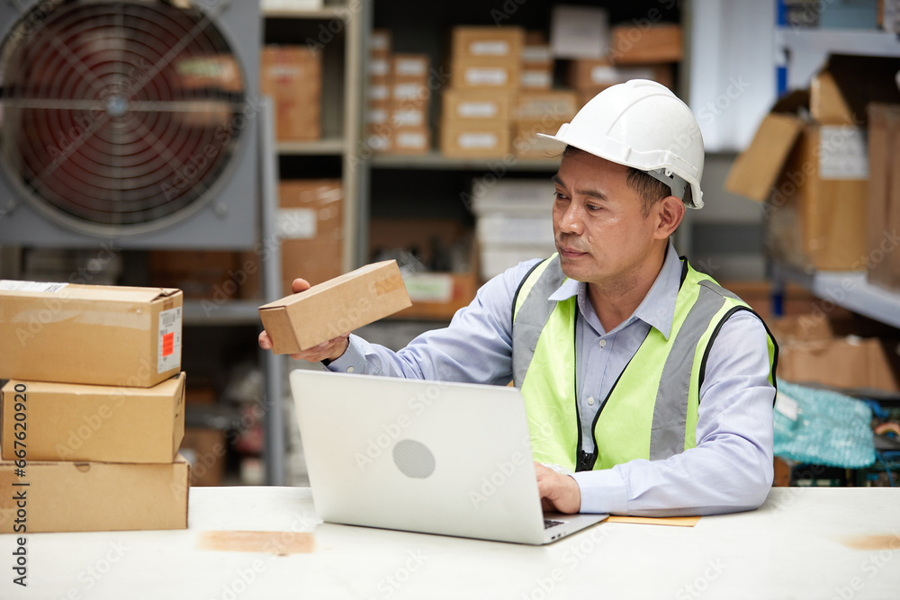 factory worker looking at cardboard box packaging in the warehouse storage factory worker looking at cardboard box packaging in the warehouse storage