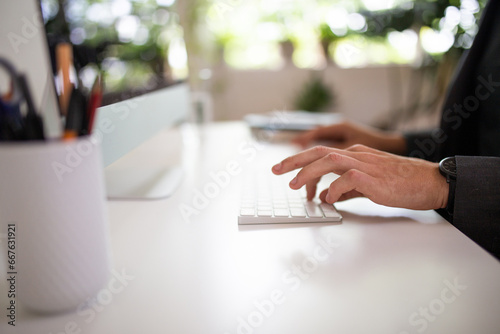 Close-up shot of man's hands typing on a keyboard photo