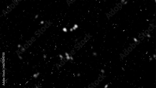 Falling snow flakes, Flying dust particles on a black background. Abstract winter background. Winter landscape with falling shining beautiful snow.