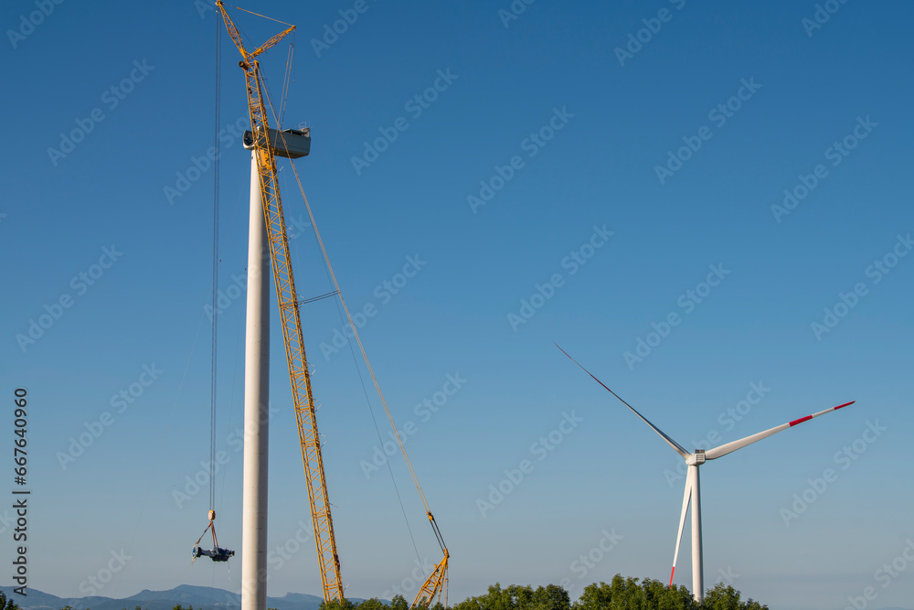 Fototapeta premium Construction site on windmill farm during the day from a distance