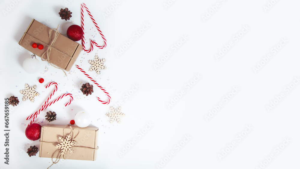 Christmas season border frame with candy canes and pine cones, gift box on white background. Creative New Year or Merry Xmas holiday composition. Winter greeting card. Christmas season border frame with candy canes and pine cones, gift box on white background. Creative New Year or Merry Xmas holiday composition. Winter greeting card.