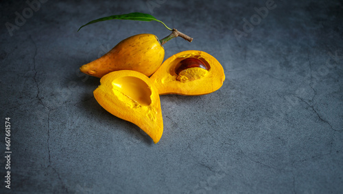 Cut in half of Canistel, Tiesa, yellow sapote, Pouteria Campechiana,Canistel, ripe, orange, gray background, Close-up photo