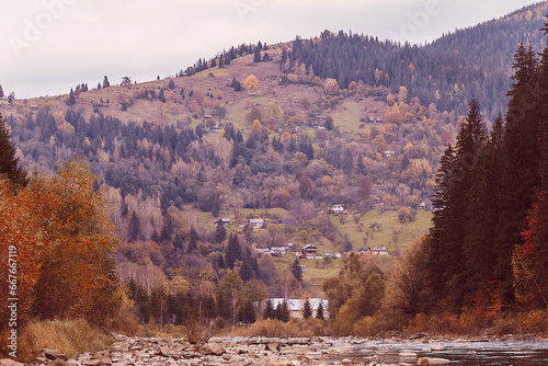 Autumn countryside view, mountain river, village and autumn atmosphere background. Cheremosh River photo