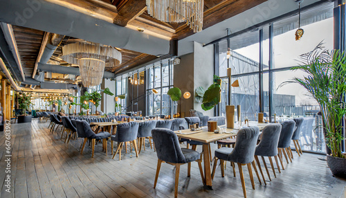 spectacular interior of the contemporary restaurant in stylish grey shades the main hall with the wooden tables chairs and velvet sofas glass wall with entrance to the terrace