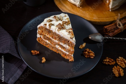 Fototapeta Naklejka Na Ścianę i Meble -  Carrot cake with butter cream and walnuts on a dark background