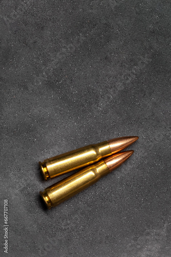Bullets for Kalashnikov assault rifle on gray concrete background, top view. Cartridge 7.62 caliber for ak 47 closeup