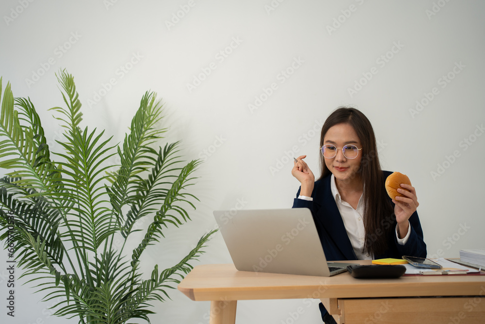 Busy and tired businesswoman eating Bread and milk for lunch at the Desk office and working to deliver financial statements to a boss. Overworked and unhealthy for ready meals, burnout concept. Busy and tired businesswoman eating Bread and milk for lunch at the Desk office and working to deliver financial statements to a boss. Overworked and unhealthy for ready meals, burnout concept.