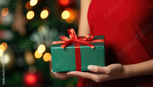 Hands holding a green gift with a ribbon on New Year's Eve or Christmas