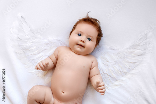 Beautiful Baby . Cute infant angel with wings isolated on white. lovely baby with wings of an angel on a white background. Happy angelic baby looking up