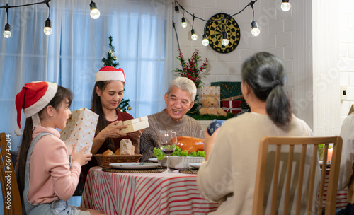 Happy Asian family celebrating Christmas at home. with the activity of giving gifts to each other among family members