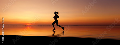 woman in a large landscape panorama running, black silhouette on an orange light of sunset on the beach with water reflection, embracing sports in concept banner, Wellness and Tranquility