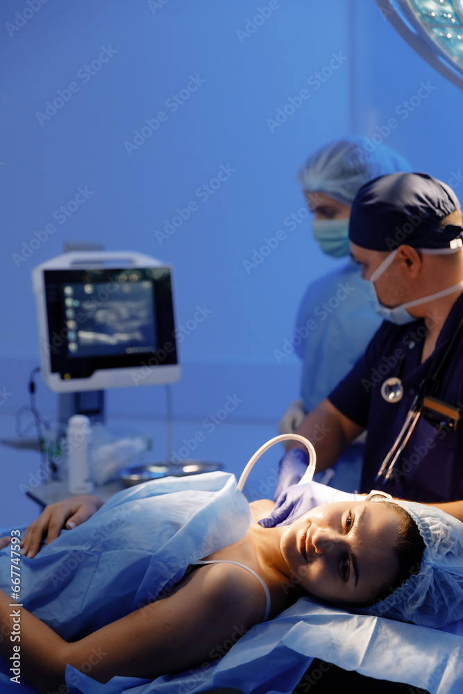 A surgeon is taking a patient vitals and making sure everything is sound before the surgery, all her vitals are coming up on the computer screen and he s concentrating A surgeon is taking a patient vitals and making sure everything is sound before the surgery, all her vitals are coming up on the computer screen and he s concentrating