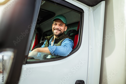 Young handsome man working in towing service and driving his truck.