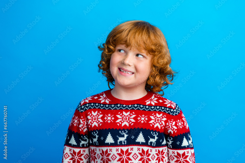 Photo of pretty dreamy small boy wear ornament sweater enjoying xmas looking empty space isolated blue color background Photo of pretty dreamy small boy wear ornament sweater enjoying xmas looking empty space isolated blue color background
