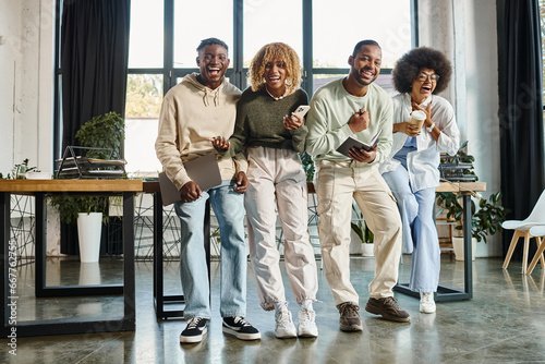 cheerful african american friends laughing sincerely while working on project, business concept