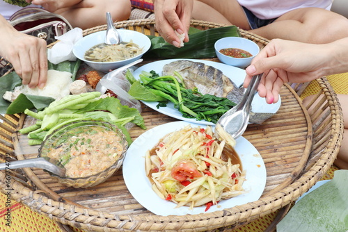 People's hands eating Thai food,Somtum, papaya salad with fish,sticky rice