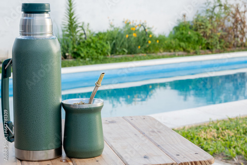 Thermos and mate, next to the pool on a table
