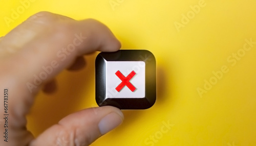 Access Revocation in a Hazardous Setting: Hand Cancelling the Click on the Red Button with an X on Yellow Background photo