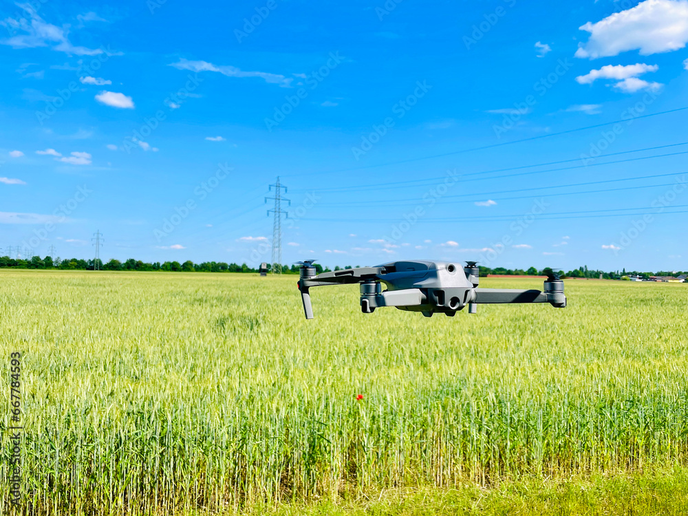 Drone hovering above wheat field, concept of using Drones in agriculture Drone hovering above wheat field, concept of using Drones in agriculture