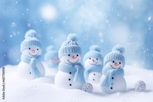 Snowman family in knitted hat and scarf on snow background. © mila103