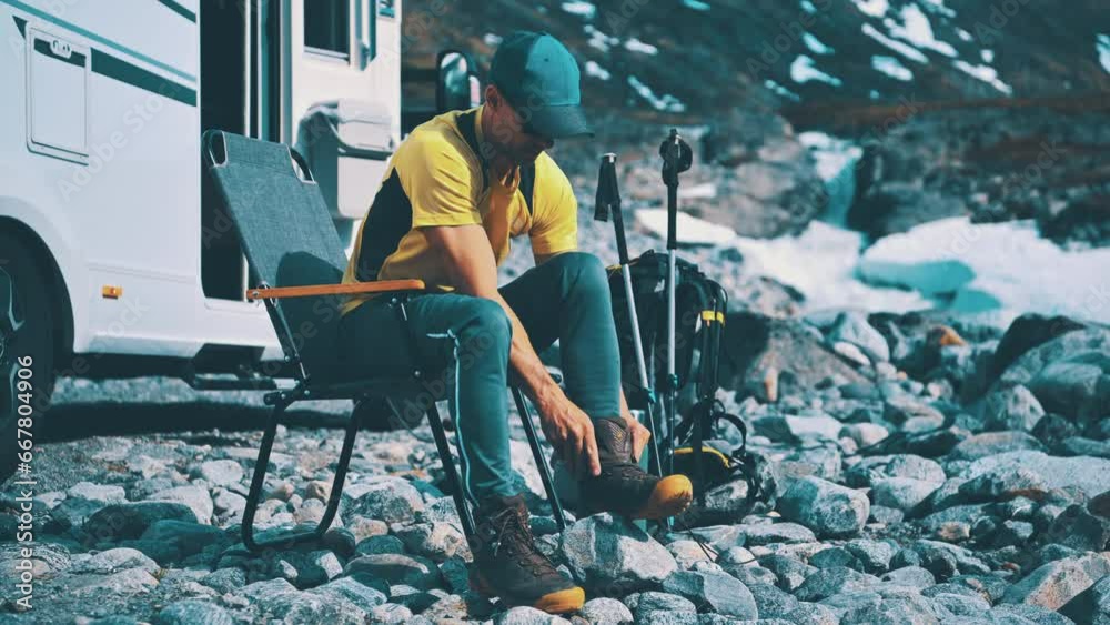 A Man Wearing Hiking Shoes in Front of His Camper Van