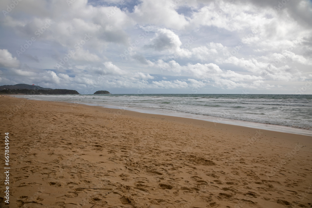 Beautiful beach on a cloudy day. Sandy beach. Waves on the sea.