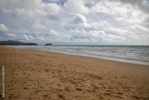 Beautiful beach on a cloudy day. Sandy beach. Waves on the sea.