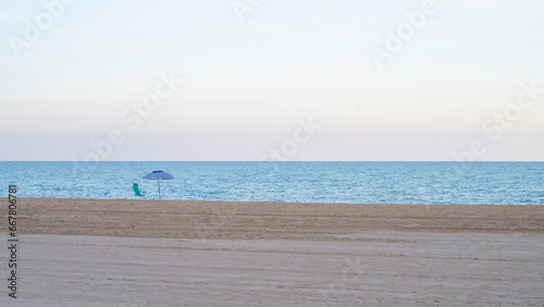 Fototapeta Naklejka Na Ścianę i Meble -  Empty beach, uncrowded, quiet, calm, with a single umbrella and a hammock.