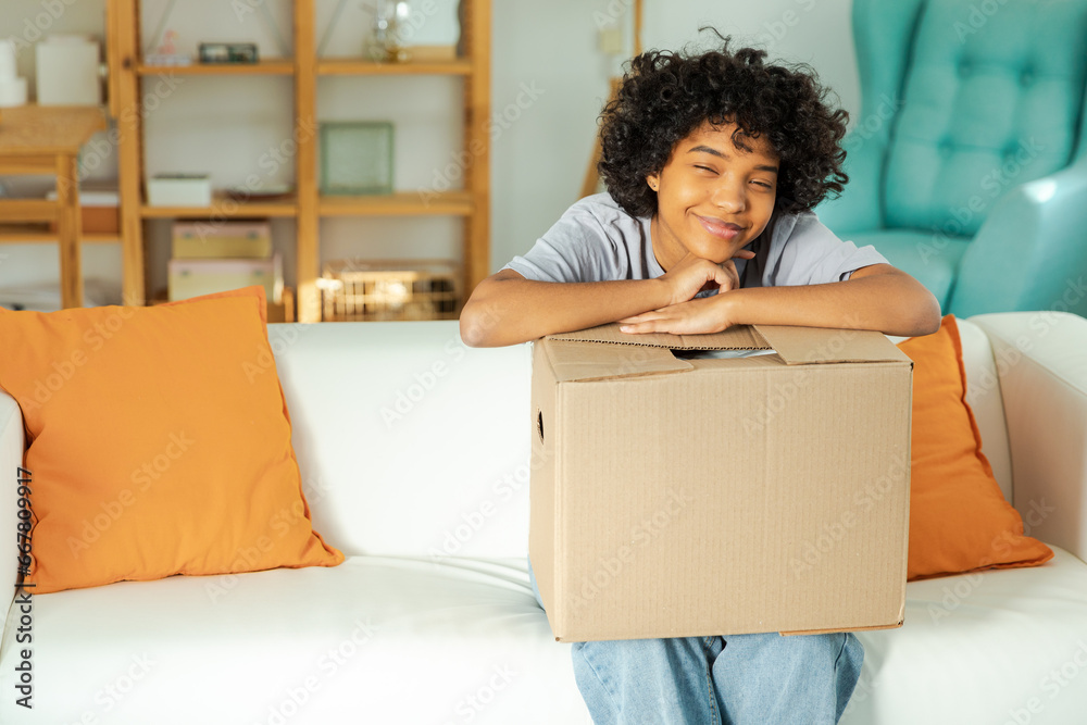 African girl unpacking delivery looking in box. Happy woman opening carton box. Female getting parcel looking at delivered goods items. Satisfied client positive feedback quick express deliver African girl unpacking delivery looking in box. Happy woman opening carton box. Female getting parcel looking at delivered goods items. Satisfied client positive feedback quick express deliver
