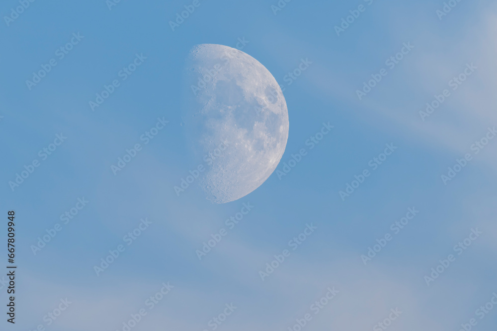 The rising moon on a soft blue sky with light clouds. The rising moon on a soft blue sky with light clouds.