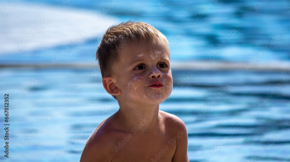 child by the pool applying sunscreen.