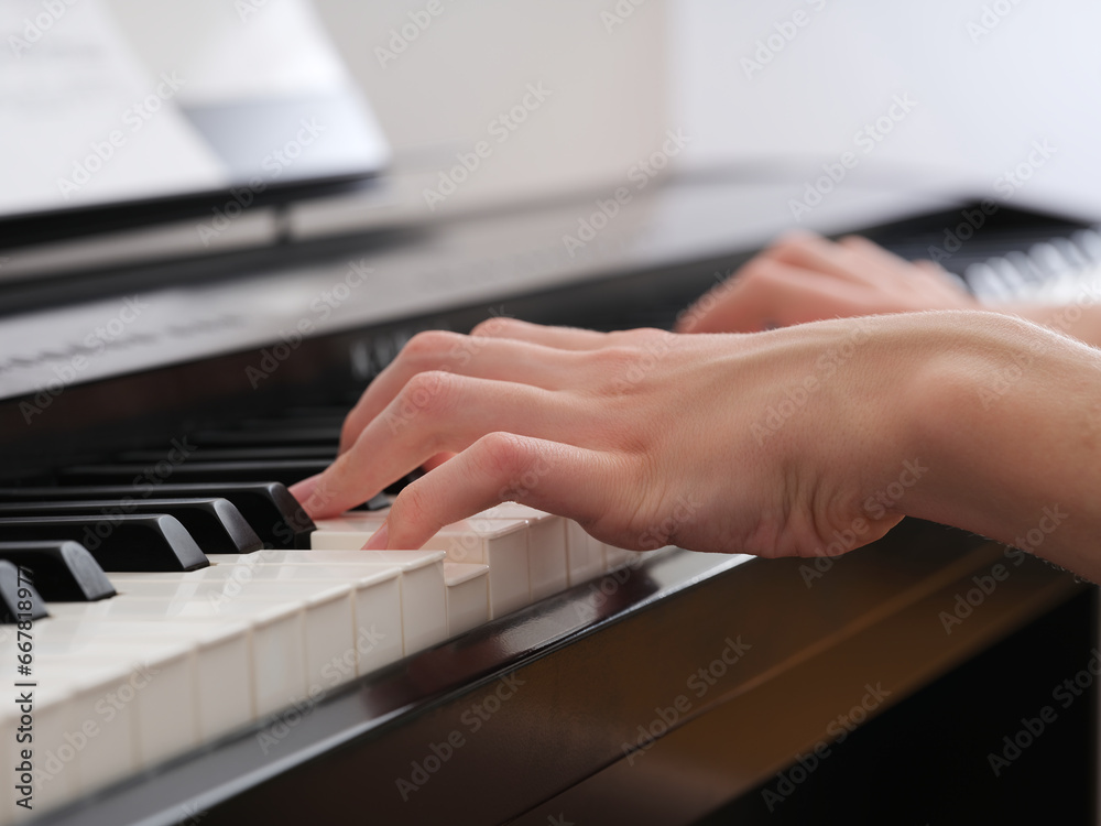 Obraz premium A young man playing on a digital piano