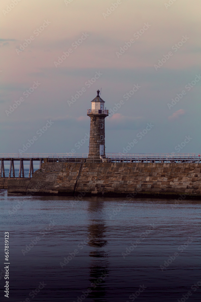 Whitby west lighthouse basking in the sunset during a cool autumn evening