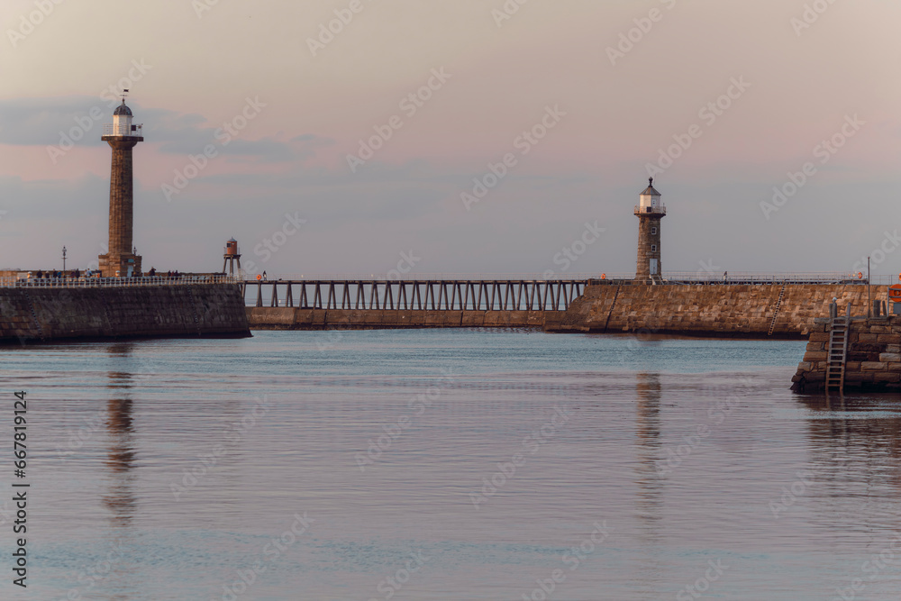 Whitby west and east pier lighthouses basking in the autumn sunset