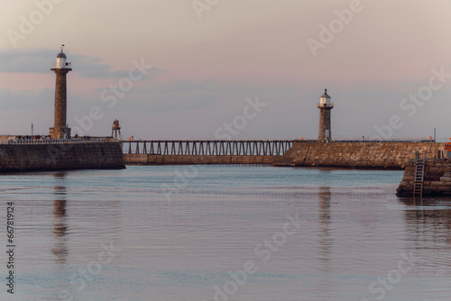 Whitby west and east pier lighthouses basking in the autumn sunset © Jordan