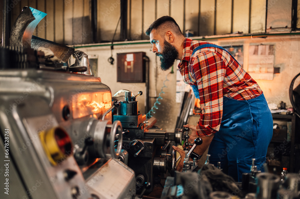 A metal turner using calipers to measure width of a cylinder in a factory. A metal turner using calipers to measure width of a cylinder in a factory.