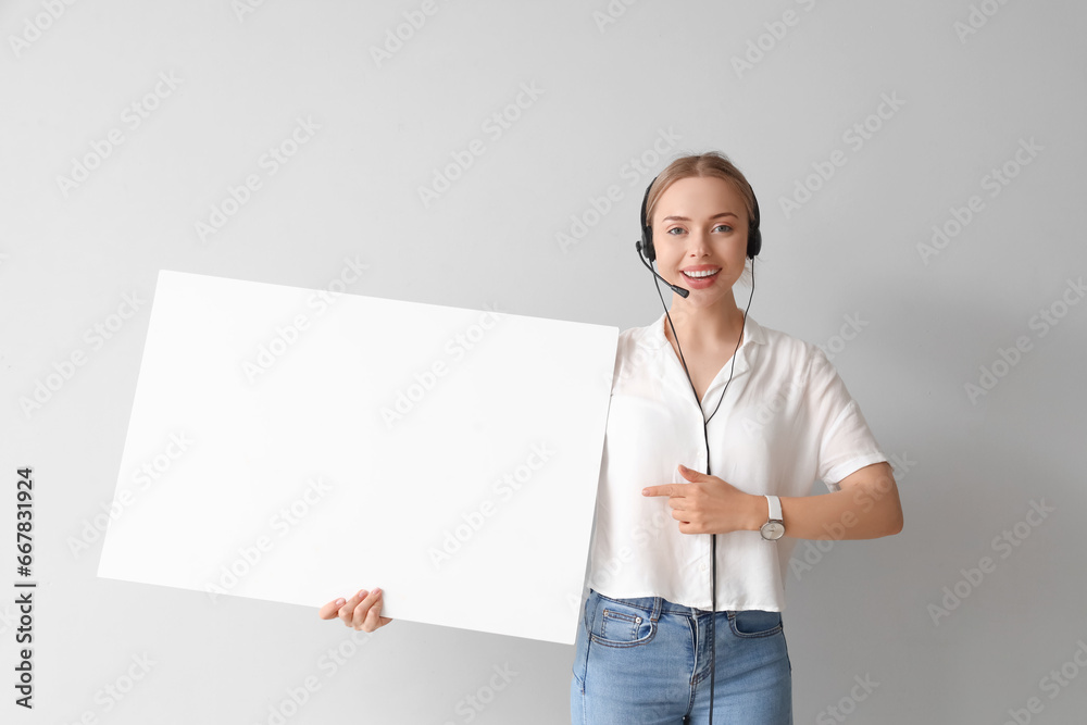 Female technical support agent with blank poster on light background Female technical support agent with blank poster on light background