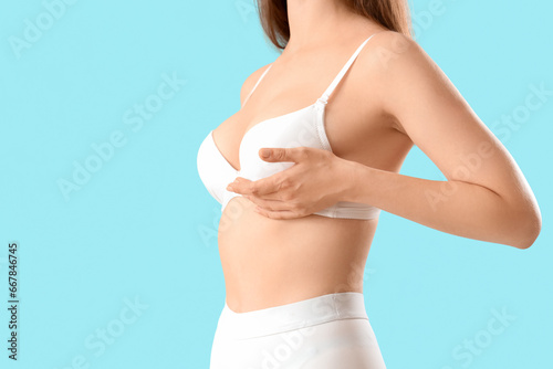 Young woman in bra on blue background photo