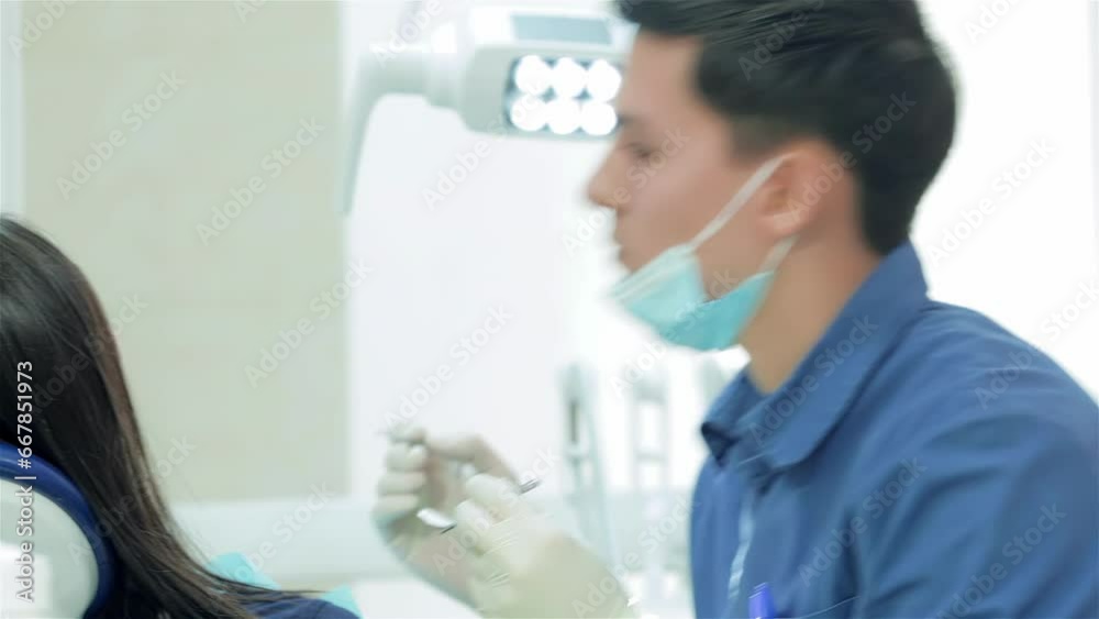 The dentist selects the tool and starts examination of the teeth The dentist selects the tool and starts examination of the teeth