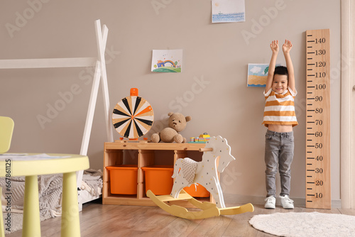 Little Asian boy measuring ...